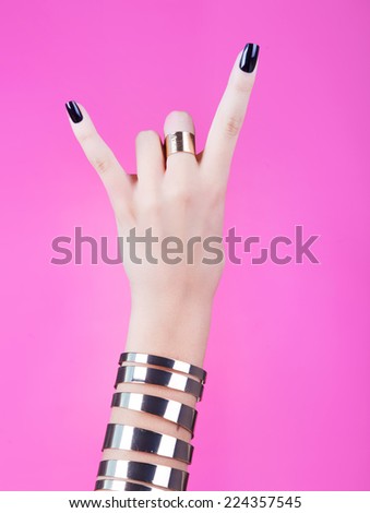 Woman hand giving the devil horns gesture 