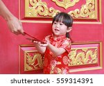 Woman hand giving red packet monetary gift for Cute little girl at chinese temple in bangkok, Thailand. Chinese new year concept.