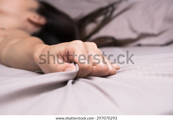 Woman hand grasp bed\
sheet