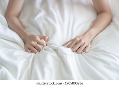 Woman Hand Grasping White Sheet. Couple Making Love Or Having Sex In Bedroom.