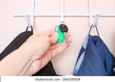 Woman Hand Hanging Keys On A Ring On A Coat Rack Hook In A Hallway, Anteroom At Home, Home Safety And Security Concept.