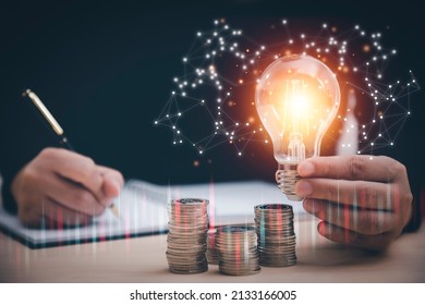 Woman hand hold light bulb with icons work on the desk, Creativity and innovation are keys success. Concept of new idea and innovation with icons and light bulbs, Save the money, Freedom of thought. - Shutterstock ID 2133166005
