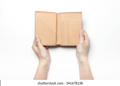 A Woman Hand Hold And Open A Brown Leather Wallet(case, Pocket, Cover) For Passport, Name Card, Credit Card On The White Desk(table, Board) Top View Isolated White At The Studio.