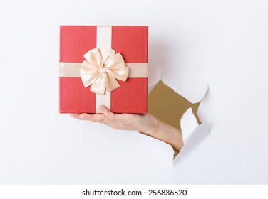 Woman Hand Hold With Present Box Break Through The Paper Wall