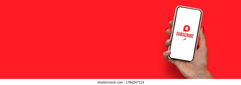 Woman Hand holding the black Mockup smartphone with a close up icon with beautiful nails. Blogger asks to subscribe to his channel for video vlogs. Mobile device isolated on red background - Powered by Shutterstock