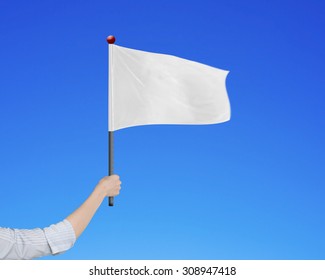 Woman Hand Holding Blank White Flag, Isolated On Blue Background.