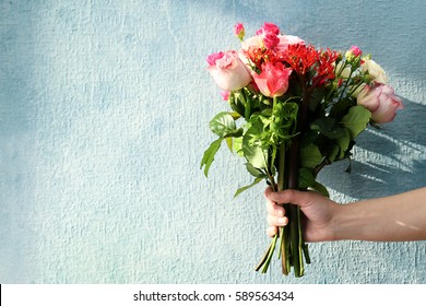 Woman Hand Holding Bouquet Of Fresh Flowers On Light Background
