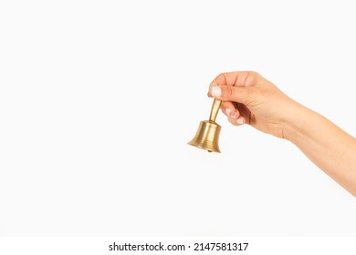 Woman hand holding bronze bell on a white background with copy space