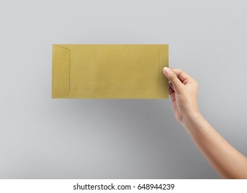 Woman Hand Holding Brown Envelope For Letter Paper On Grey Background.