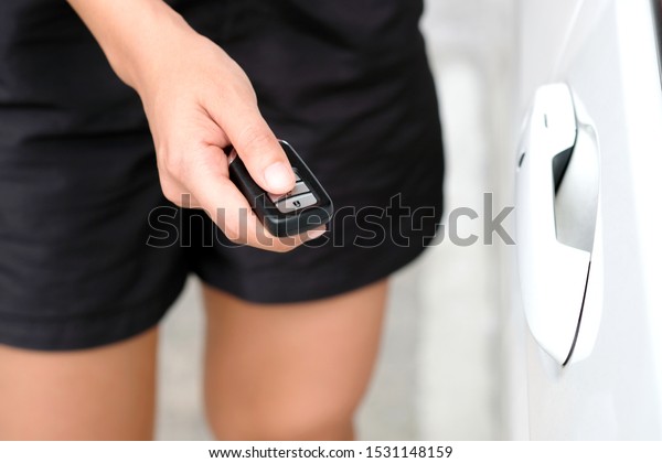 woman hand holding the car remote, he push the
remote control to open the car
door