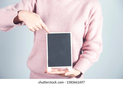 woman hand holding chalkboard on gray background
