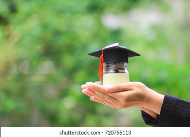 Woman hand holding coins money in glass bottle with graduates hat on natural green background, Saving money for education concept - Shutterstock ID 720755113