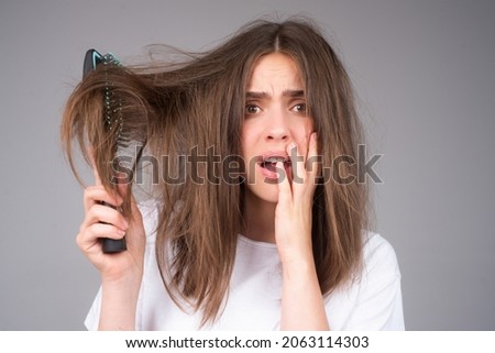 Woman hand holding comb with serious hair loss problem for health care shampoo.