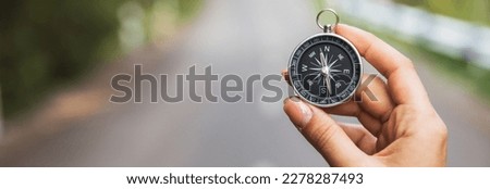 woman hand holding compass in road background
