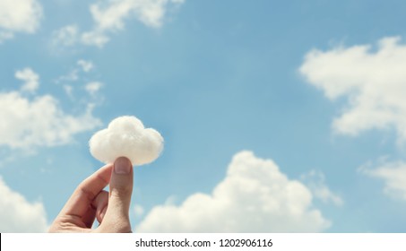 Woman hand holding cotton wool on cloud sky background. The development of the imagination, copy space. - Shutterstock ID 1202906116