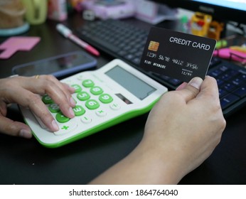 woman hand holding creadit card with calculator for shopping online.