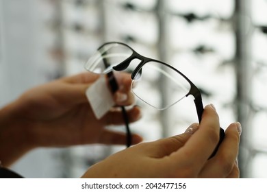 Woman hand holding the eyeglasses in optics store, close up