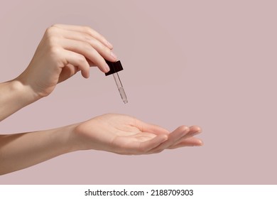 Woman hand holding facial essential oil or serum packaging on pink background. Beauty cosmetic product for skincare concept. Mockup. High quality photo - Powered by Shutterstock