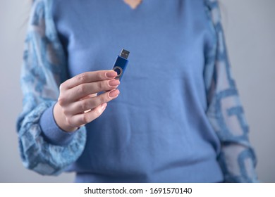 Woman Hand Holding Flash Drive On Grey Background