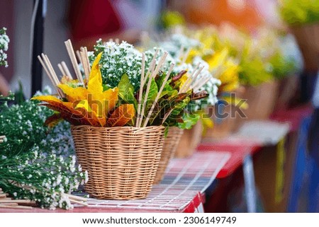 woman hand holding flower basket Chiang Mai City Pillar Inthakin Festival, crowd buddhist people make merit with flowers in Wat Chedi Luang 