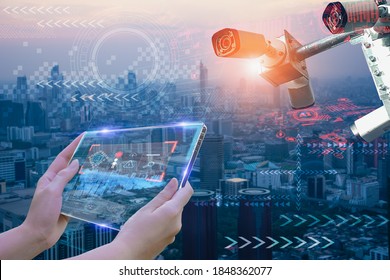 Weibliche Hand, die futuristische Tablet-Geräte hält, um die Sicherheit zu überwachen und die Informationen und das Verhalten der Menschen in der Stadt zu speichern,Konzept cctv Kamera intelligent von künstlicher Intelligenz in der Stadt für Sicherheit in der Sicherheit