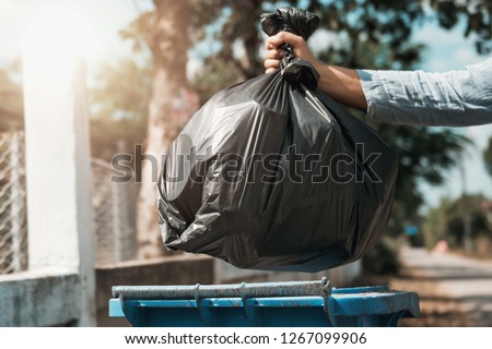 woman hand holding garbage black bag put in to trash