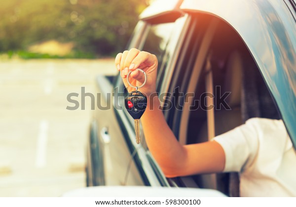 Woman hand holding, giving key of auto car,\
motor vehicle. Concept of dealership, first, used or new car.\
People is dealer person, salesman, agent, buyer or customer. To\
sale, rent, buy or\
purchase.