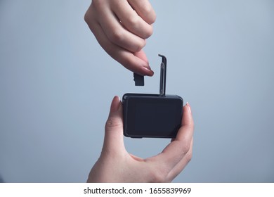 Woman Hand Holding Gopro On Grey Wall Background