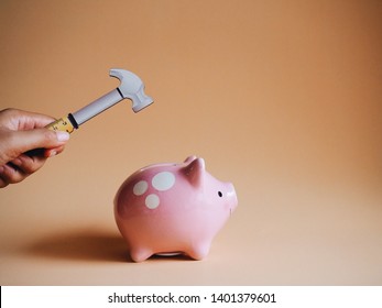 Woman hand holding a hammer for hitting piggy bank. - Shutterstock ID 1401379601