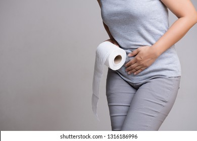 Woman hand holding her crotch lower abdomen and tissue or toilet paper roll. Disorder, Diarrhea, incontinence. Healthcare concept.
