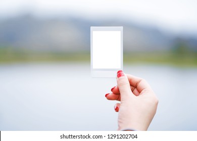 Woman Hand Holding Instant Photo Frame On Nature Background.