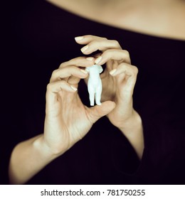 Woman Hand Holding Little Doll, Melancolic Sensual Studio Shot With Black Background