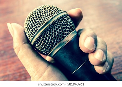 Woman hand holding a microphone,Old microphone