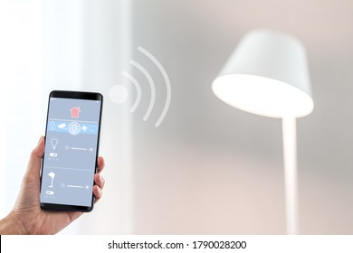 Woman Hand Holding Mobile Phone Showing Smart Home App Screen On Lighting Control Page