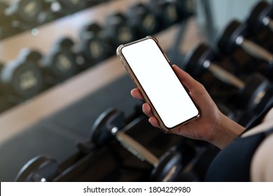 Woman Hand Holding Mobile Phone With Blank White Screen Mockup In Gym.