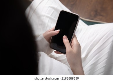 Woman Hand Holding Mobile Phone And Sitting On Sofa.