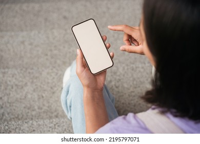 Woman hand holding mobile phone shopping online looking at empty display sitting outdoors, selective focus. Modern female using mobile app, pointing finger. Mockup  - Powered by Shutterstock