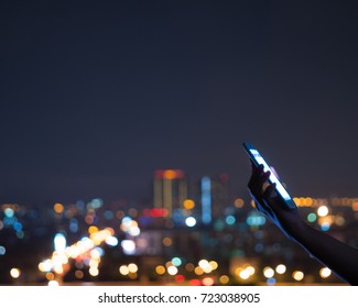 Woman Hand Holding Mobile Phone At Night Bokeh City Light Background