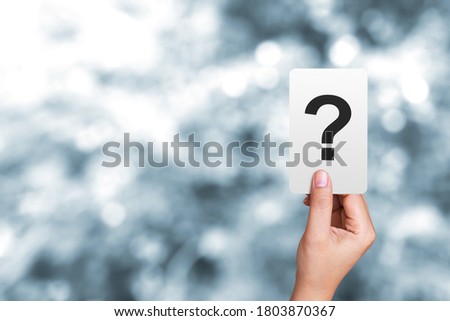 Woman hand holding a note written a question mark