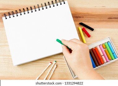 Woman Hand Holding Oil Pastel Art Picking For Art Drawing On Paper And Set Box Of Colorful Crayons On Wood Table Background With Copy Space For Text.