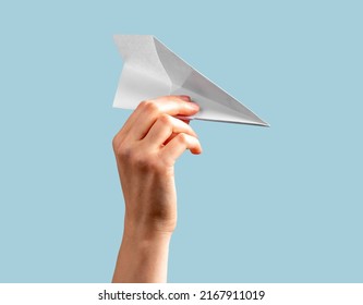 Woman Hand Holding Origami Plane On Blue Background. Flying Paper Airplane. High Quality Photo