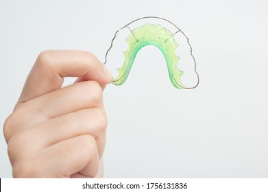 woman hand  holding orthodontic retainers.Teeth retaining tools after braces. concept Orthodontics Dental. - Shutterstock ID 1756131836