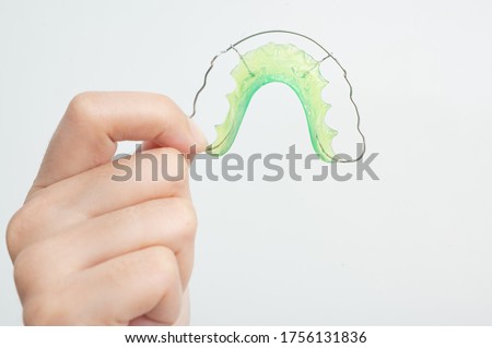 woman hand  holding orthodontic retainers.Teeth retaining tools after braces. concept Orthodontics Dental.