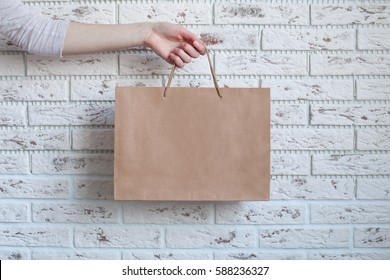 woman hand holding paper bag, blank craft paper package.mock-up shopping bag