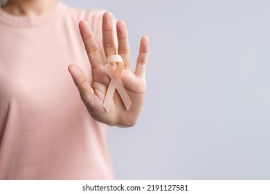 woman hand holding Peach Ribbon for September Uterine Cancer Awareness month. Healthcare and World cancer day concept - Powered by Shutterstock