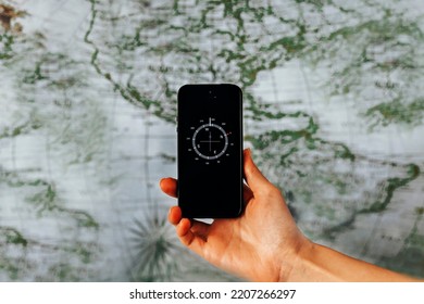 Woman Hand Holding Phone Compass With Map Background