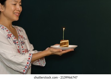 Woman Hand Holding A Piece Of Birthday Cake On The Plate With Candle