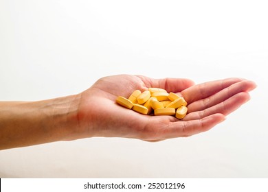 Woman Hand Holding Pill On White Background