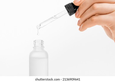 Woman hand holding pipette with collagen moisturizing hyaluron serum and drops the clear serum into the bottle. - Powered by Shutterstock