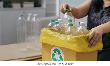 Woman hand holding recycle plastic bottle put in paper garbage bin at home
 - Powered by Shutterstock